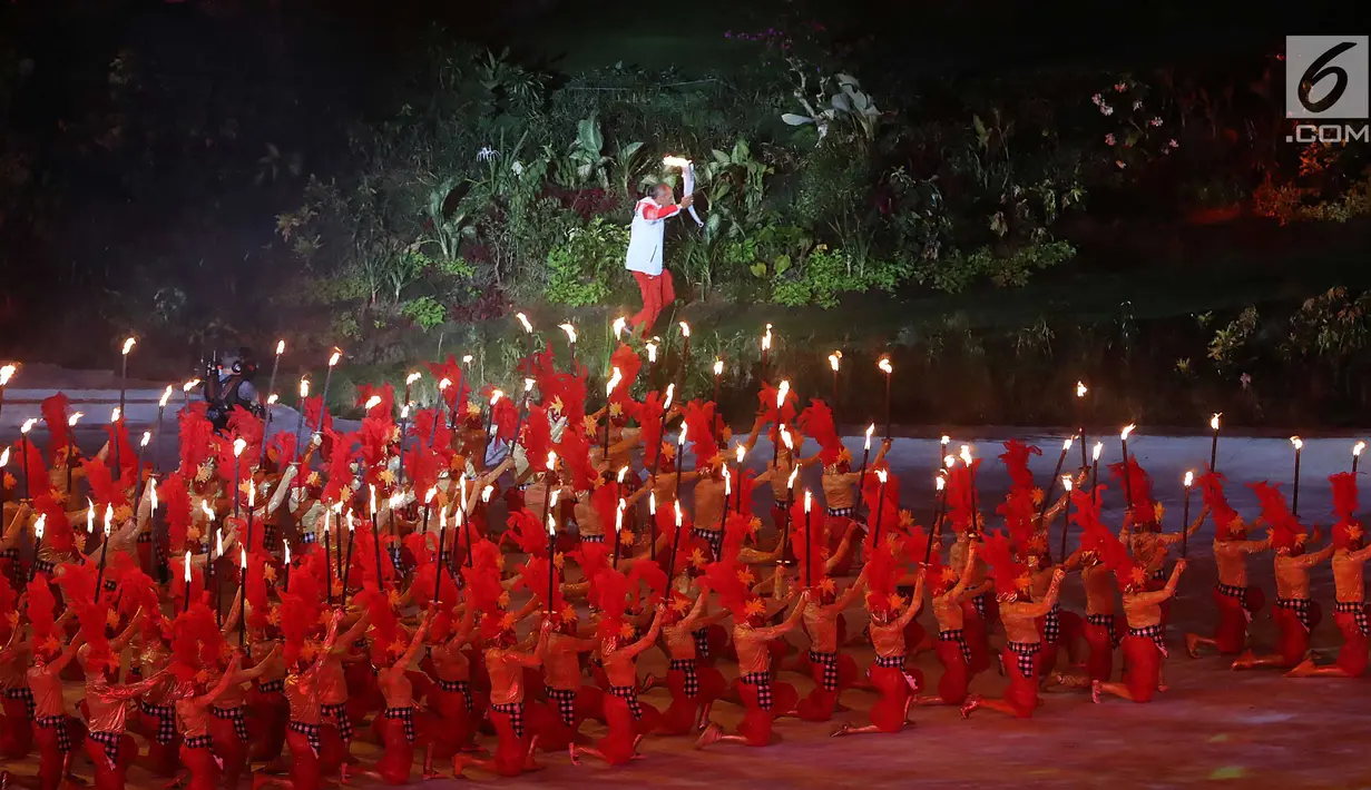Peraih dua medali emas Asian Games 1978 dan dua medali emas Asian Games 1982 Yustedjo Tarik membawa obor Asian Games 2018 saat pembukaan di Stadion Utama Gelora Bung Karno (SUGBK), Jakarta, Sabtu (18/8). (Liputan.com/Fery Pradolo)