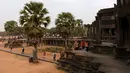 Turis mengunjungi candi Angkor Wat di provinsi Siem Reap pada 16 Maret 2019. Angkor Wat memegang peranan penting bagi perekonomian Kamboja karena merupakan destinasi dari 50 % turis yang tiba di Kamboja. (TANG CHHIN Sothy / AFP)
