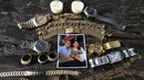 Foto dan perhiasan milik jurnalis Honduras David Romero, kepala stasiun radio dan TV Globo, yang meninggal karena komplikasi dari COVID-19 pada 18 Juli, diambil di rumahnya di Tegucigalpa, 22 Juli 2020. Sepertiga dari kematian global akibat COVID-19 terjadi di Amerika Latin. (Orlando SIERRA/AFP)