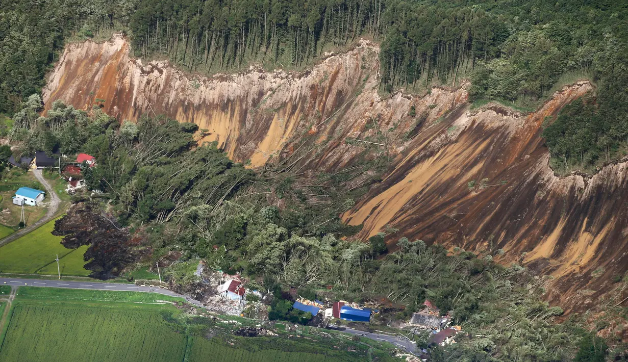 Pemandangan tanah longsor setelah gempa mengguncang Kota Atsuma, Prefektur Hokkaido, Jepang, Kamis (6/9). Gempa menghancurkan sejumlah rumah dan merobohkan tiang listrik. (Kyodo News via AP)