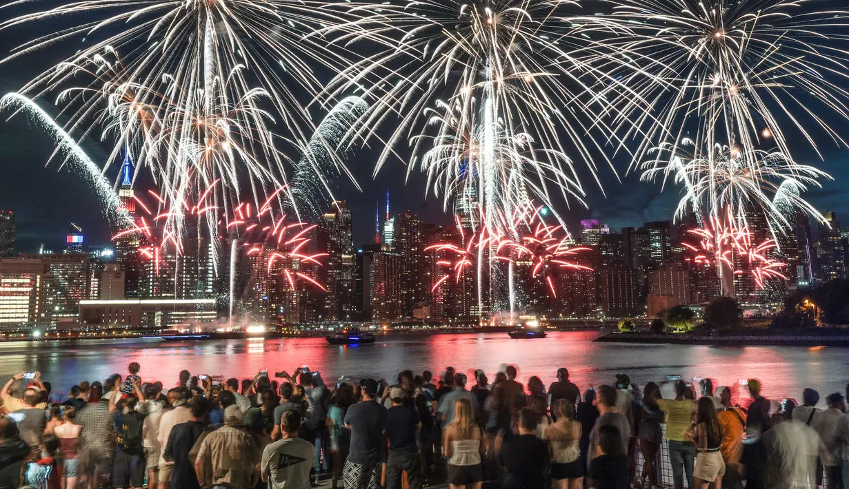 Penonton berkumpul di sepanjang tepi pantai Williamsburg untuk menyaksikan pertunjukan kembang api Macy pada perayaan Hari Kemerdekaan di Brooklyn, New York, Amerika Serikat, 4 Juli 2022. Kembang api meledak dari tongkang di East River. (AP Photo/Bebeto Matthews)