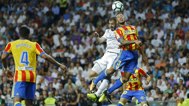 Striker Real Madrid, Karim Benzema (dua dari kiri), terlibat duel udara melawan pemain Valencia, Ruben Vezo pada lanjutan Liga Spanyol di Estadio Santiago Bernabeu, Senin (28/8/2017), dini hari WIB. Real Madrid ditahan Imbang 2-2. (AP/Francisco Seco)