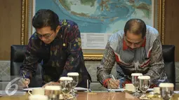 Ketua OJK,  Muliaman D. Hadad (kiri) bersama Menpar Arief Yahya menandatangani MoU di Jakarta, Selasa (19/4). MoU tersebut terkait pengembangan destinasi dan industri pariwisata melalui Lembaga Jasa Keuangan. (Liputan6.com/Faizal Fanani)