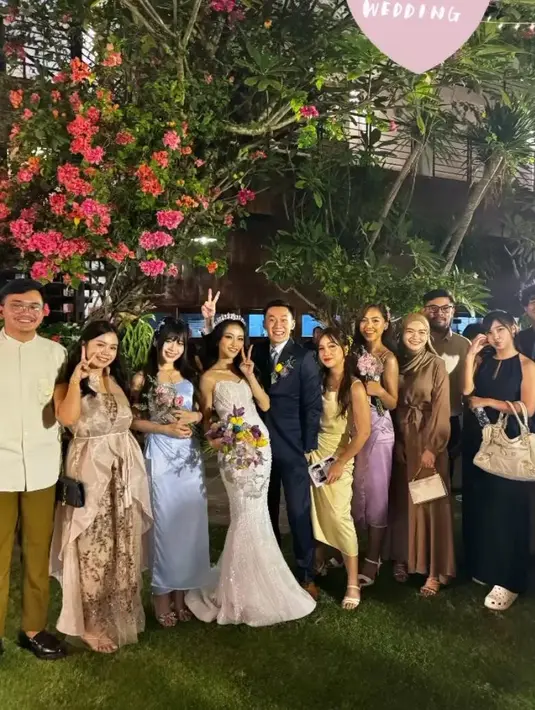 Cindy Yuvia mengenakan wrap dress satin berwarna biru muda. Penampilannya dipermanis dengan headpiece warna senada di kepalanya. Di sampingnya ada Aurel yang mengenakan dress senada namun dengan warna hijau sage. [@nadilawantari23/@_siscasaras_/@rona_ang]