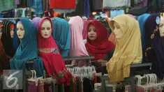 Seorang paramuniaga mengawasi model jilbab yang di jual di pasar Beringharjo, Yogyakarta, Rabu, (8/6/2016). Saat bulan ramadan, penjualan pakaian muslim mengalami peningkatan. (Liputan6.com/Boy Harjanto)