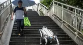 Foto yang diambil pada 22 September 2023 ini menunjukkan demonstrasi robot anjing X30 dari DEEP Robotics yang berjalan menuruni anak tangga di jalur pejalan kaki di kota tuan rumah Asian Games 2022, Hangzhou, di provinsi Zhejiang, China bagian timur. (Philip FONG / AFP)