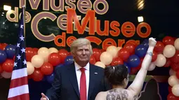 Aktivis Femen bertelanjang dada di depan patung lilin Presiden AS terpilih Donald Trump saat acara pembukaan Madrid's wax museum di Madrid, Spanyol, Selasa (17/1). (AFP PHOTO/GERARD JULIEN)