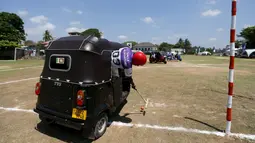 Peserta memukul bola saat tampil di kompetisi "Tuk Tuk Polo" di Galle, Sri Lanka, (21/2). Tuk Tuk merupakan kendaraan roda tiga atau bisasa dikenal Bajaj yang menjadi alat transportasi warga Sri Lanka. (REUTERS/Dinuka Liyanawatte)