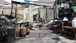 Kebakaran dipicu kericuhan pasca pengeroyokan yang melibatkan mata elang (sebutan untuk penagih utang di lapangan) dengan orang tidak dikenal yang terjadi di kawasan Kalibata, Jakarta Selatan pada Kamis (11/12/2025) sore. Tampak dalam foto, pemilik kios membersihkan puing-puing bangunan usai kebakaran yang melanda deretan kios di kawasan Kalibata, Jakarta Selatan, pada Jumat (12/12/2025). (merdeka.com/magang/Rendi Saputra)