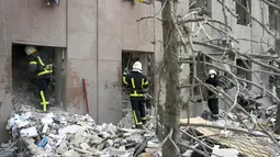 Petugas pemadam kebakaran membersihkan puing-puing gedung pemerintah yang terkena roket Rusia di Mykolaiv (29/3/2022). Gubernur Vitaly Kim mengatakan bahwa kebanyakan orang di dalam gedung tidak terluka tetapi beberapa warga sipil dan tentara belum ditemukan. (AFP/Bulent Kilic)