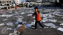 Petugas membersihkan sampah koran di ruas Jalan Jatinegara Barat, Jakarta, Jumat (17/7/2015). Sampah koran bekas tersebut sebelumnya digunakan warga untuk alas salat Idul Fitri 1436 H. (Liputan6.com/Johan Tallo)