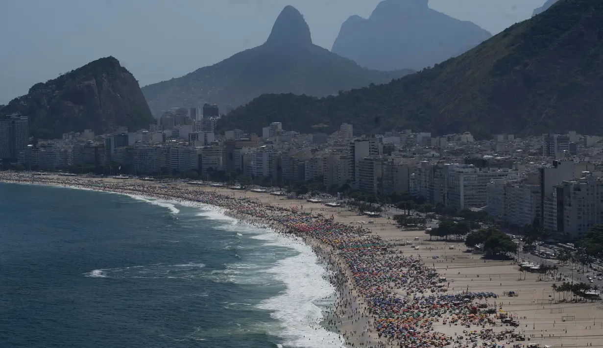 Orang-orang menikmati hari di pantai Copacabana di Rio de Janeiro, Brasil, pada 16 Februari 2025. (Pablo PORCIUNCULA/AFP)
