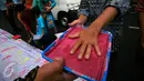 Warga mewarnai telapak tanganya sebagai upaya mendukung gerakan pencegahan paham radikal terorisme dan ISIS di Maliboro, Yogyakarta, (29/10/2015). Acara yang di gelar BNPT juga membagikan buku - buku bahaya ISIS radikalisme teroris. (Boy T Harjanto)