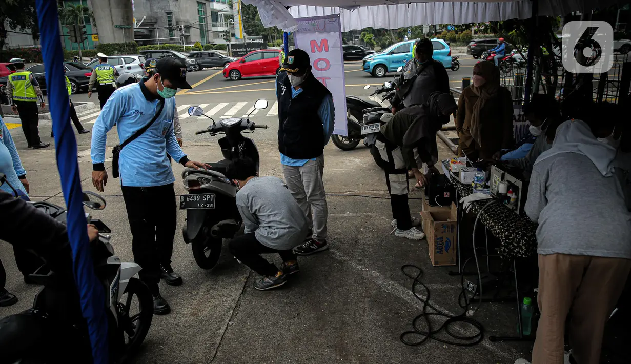 Seorang petugas mengecek emisi gas buang kendaraan bermotor di kawasan Terminal Blok M, Jakarta, Selasa (11/10/2022). Pemerintah Kota Jakarta Selatan menggelar uji emisi gratis untuk kendaraan bermotor dalam rangka sosialisasi Peraturan Gubernur Nomor 66 Tahun 2020. (Liputan6.com/Faizal Fanani)