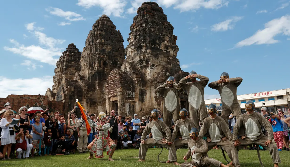 Penari dengan kostum monyet menari di hadapan wisatawan selama Festival Monkey Buffet, kuil Phra Prang Sam Yot, Bangkok, Thailand (27/11). (REUTERS/Chaiwat Subprasom)