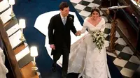 Putri Eugenie dari York dan Jack Brooksbank berjalan kembali menyusuri lorong setelah upacara pernikahan mereka di St George’s Chapel, Windsor Castle, di Windsor, pada tanggal 12 Oktober 2018. (OWEN HUMPHREYS/AFP)