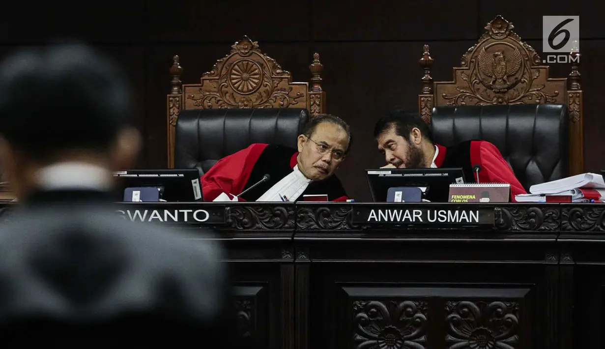 Ketua Majelis Hakim Mahkamah Konstitusi Anwar Usman (kanan) berbincang saat mendengarkan keterangan Ketua Tim Hukum Joko Widodo-Ma’ruf Amin, Yusril Ihza Mahendra dalam sidang sengketa Pilpres 2019 di Gedung MK, Jakarta, Selasa (18/6/2019). (Liputan6.com/Faizal Fanani)