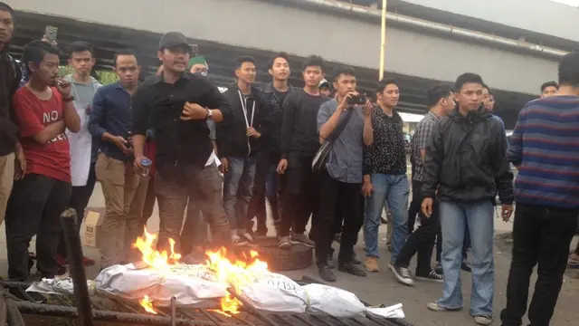 Massa HMI Unibos Makassar bakar mayat buatan di depan kantor Kejati Sulsel (Liputan6,com/ Eka Hakim)