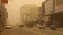 Mobil melaju di jalan selama badai debu di kota Nasiriyah Irak di provinsi Dhi Qar selatan (9/4/2022). Badai debu telah melanda sebagian besar Irak, meninggalkan puluhan orang di rumah sakit dengan masalah pernapasan. (AFP/Shwan Nawzad)