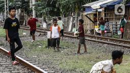 Anak-anak bermain bola di tengah perlintasan kereta api kawasan Ancol, Jakarta Utara, Kamis (19/5/2022). Kelompok umur kasus diduga hepatitis akut terbanyak adalah di bawah 5 tahun ada tujuh kasus, 6 sampai 10 tahun ada dua kasus, dan 11-16 tahun ada lima kasus. (Liputan6.com/Johan Tallo)