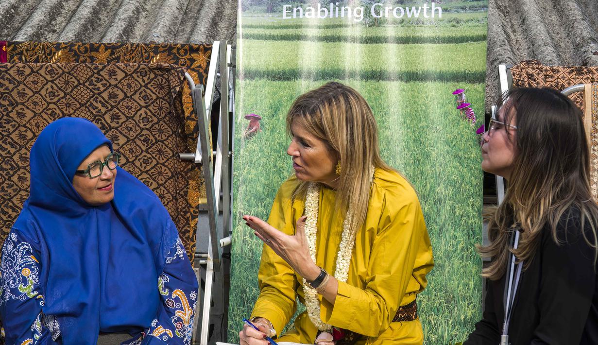 Ratu Maxima juga berkesempatan untuk belajar dan mencoba membatik secara langsung. Tampak dalam foto, Ratu Maxima dari Belanda (tengah), dalam kapasitasnya sebagai Advokat Khusus Sekretaris Jenderal PBB untuk Keuangan Inklusif untuk Pembangunan (UNSGSA), berbincang dengan seorang seniman batik (kiri) di Kampung Batik Laweyan, Surakarta, Jawa Tengah, pada Selasa 25 November 2025. (DEVI RAHMAN/AFP)