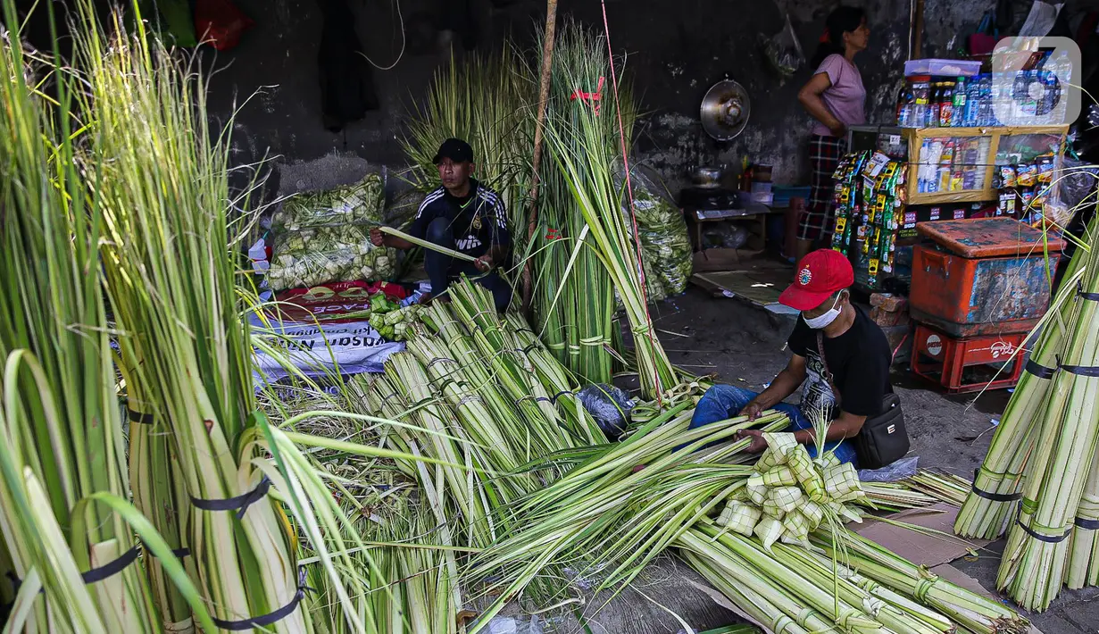 Pedagang membuat cangkang ketupat di kawasan Palmerah, Jakarta, Minggu (18/7/2021). Sepinya pembeli membuat para pedagang menjual cangkang ketupat hanya dengan harga Rp 5 ribu per ikat, padahal biasanya Rp 8 ribu per ikat. (Liputan6.com/Faizal Fanani)