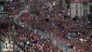Para fans menyambut kedatangan pemain Liverpool saat parade juara Liga Champions 2019 di Liverpool, Minggu (2/6). Ribuan fans tumpah ruah di jalanan untuk merayakan keberhasilan pemain membawa pulang trofi Si Kuping Besar ke kota Liverpool. (AP/Danny Lawson)