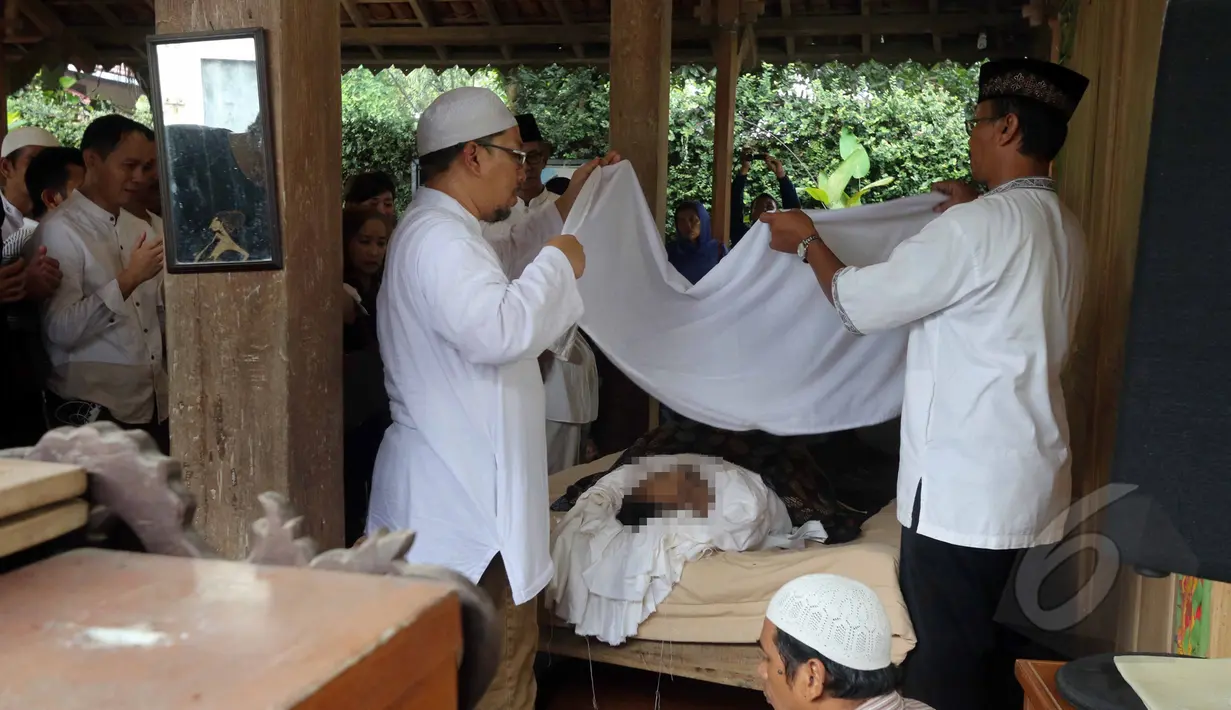 Jenazah Didi Petet terlihat sedang dikafani oleh keluarga dan kerabat almarhum di musala di rumah kediaman almarhum di kawasan Ciputat, Tangerang Selatan, Jumat (15/5/2015). Didi Petet meninggal di usia 58 tahun karena sakit. (Liputan6.com/Helmi Afandi)