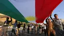 Etnis Kurdi Irak membentangkan bendera Kurdi saat melakukan aksi untuk meminta referendum kemerdekaan di Arbil, Irak utara (13/9). Mereka meminta referendum untuk menentukan kemerdekaan etnis Kurdi di Irak. (AFP Photo/SAfim Hamed)