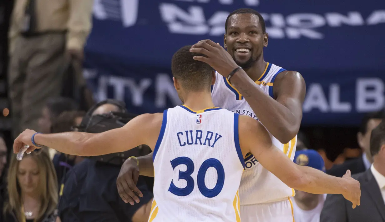 Ekspresi pemain Warriors, Kevin Durant (kanan) memeluk rekannya Stephen Curry #30 usai mengalahkan Toronto Raptors pada lanjutan NBA basketball game di Oracle Arena, (28/12/2016). Warriors menang 121-111. (Reuters/Kyle Terada-USA TODAY Sports)