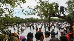 Penduduk desa menangkap ikan selama upacara penangkapan ikan tahunan di komune Choam Krovean di provinsi Tboung Khmum pada 18 Februari 2023. Dengan menggunakan keranjang bambu buatan tangan dan jaring nilon, ratusan orang mengarungi danau berlumpur setinggi paha di Kamboja timur pada hari Sabtu untuk upacara penangkapan ikan tahunan, di mana hanya alat-alat tradisional yang digunakan. (AFP/Tang Chhin Sotthy)