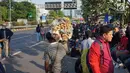 Seorang pedagang asongan menawarkan dagangannya di antara massa aksi di jalan tol dalam kota yang berada di depan Gedung DPR RI, Jakarta, Senin (30/9/2019). Adanya aksi unjuk rasa di sekitar lokasi dimanfaatkan para pedagang asongan untuk mencari rezeki. (Liputan6.com/Immanuel Antonius)