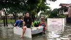 Orang-orang menaiki rakit darurat melewati jalan yang tergenang banjir di sebuah desa di Cainta Town, sebelah timur Manila pada 22 Juli 2025, setelah hujan monsun. (Ted ALJIBE/AFP)