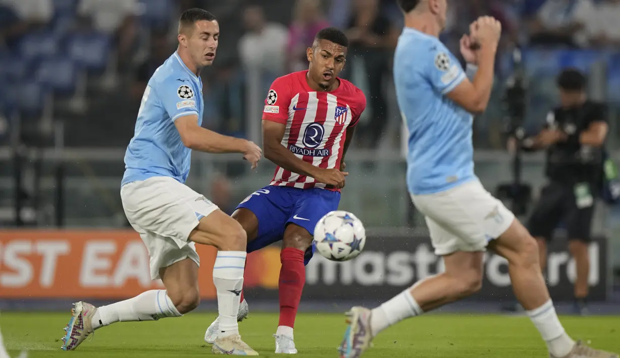 Penyerang Atletico Madrid Samuel Lino menendang bola yang ditantang oleh pemain Lazio Adam Marusic dan Patric pada Matchday 1 Liga Champions di Stadio Olimpico, Rabu (20/9/2023) dini hari WIB. (AP Photo/Andrew Medichini)
