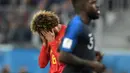 Gelandang Belgia, Marouane Fellaini menutupi wajahnya lantaran kecewa kalah dari Prancis pada semifinal Piala Dunia 2018 di Stadion St. Petersburg, Selasa (10/7). Upaya Belgia tampil di final berakhir usai takluk 0-1 dari Prancis. (AFP/GABRIEL BOUYS)