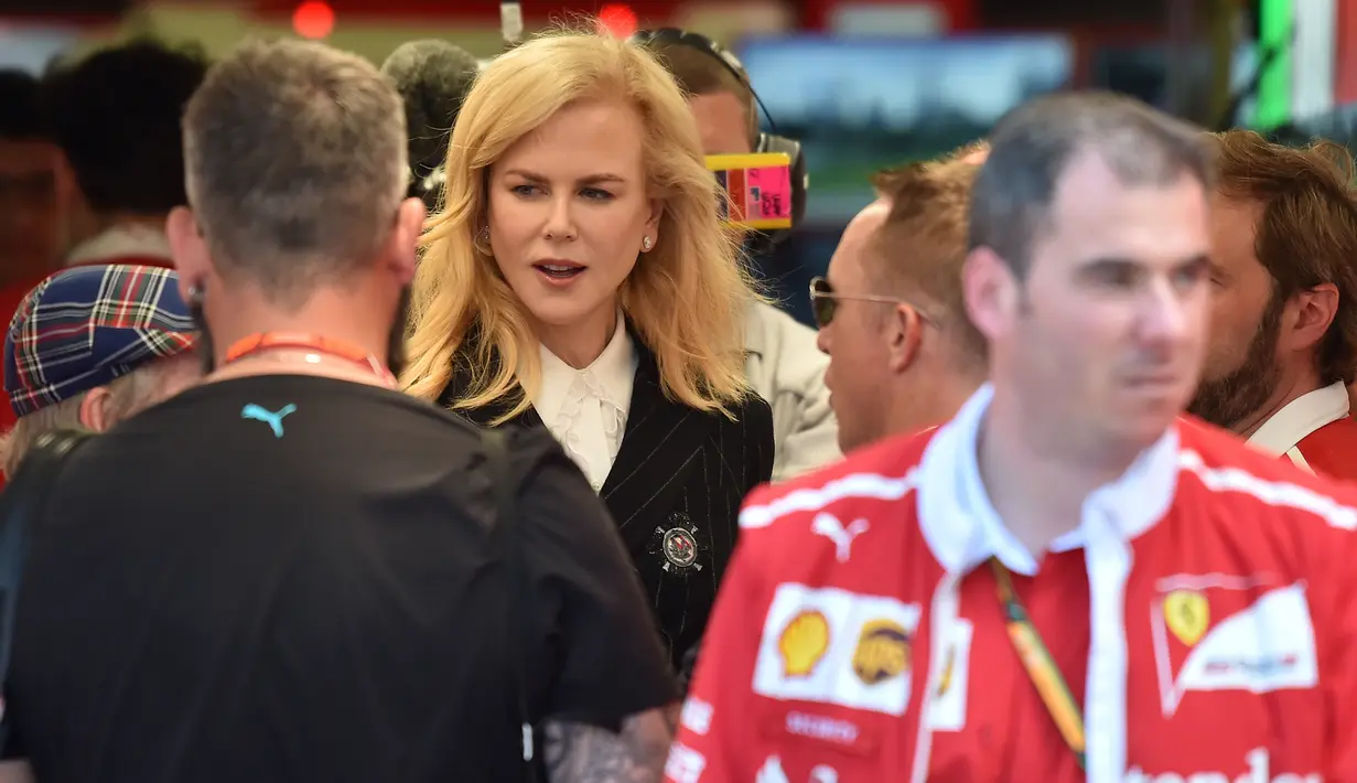 Aktris Australia, Nicole Kidman bertemu dengan anggota tim Ferarri jelang Grand Prix F1 Australia di Melbourne, Sabtu (25/3). Aktris 49 tahun itu tampil kasual dengan mengenakan kemeja putih dengan blazer hitam dan celana panjang jeans. (AFP/Paul Crock)