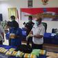 Kurir sabu dari sindikat narkoba internasional memegang barang bukti narkoba yang disita Badan Narkotika Nasional Provinsi Riau. (Liputan6.com/M Syukur)