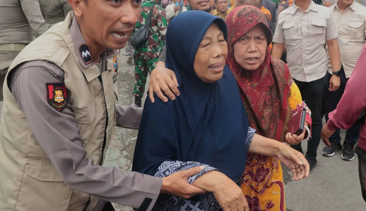 Sebanyak 102 santri korban ambruknya bangunan musala di Pondok Pesantren (Ponpes) Al Khoziny di Sidoarjo, Jawa Timur berhasil dievakuasi. Tampak dalam foto, petugas polisi membantu seorang perempuan berjalan keluar setelah bangunan runtuh di sebuah pesantren di Sidoarjo, Jawa Timur, Selasa 30 September 2025. (AP Photo/Trisnadi)