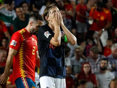 Gelandang Kroasia, Luka Modric menutupi wajahnya setelah bek Spanyol, Sergio Ramos mencetak gol kelima selama pertandingan UEFA Nations League di stadion Manuel Martinez Valero, Spanyol (11/9). Spanyol menang 6-0 atas Kroasia. (AP Photo/Alberto Saiz)