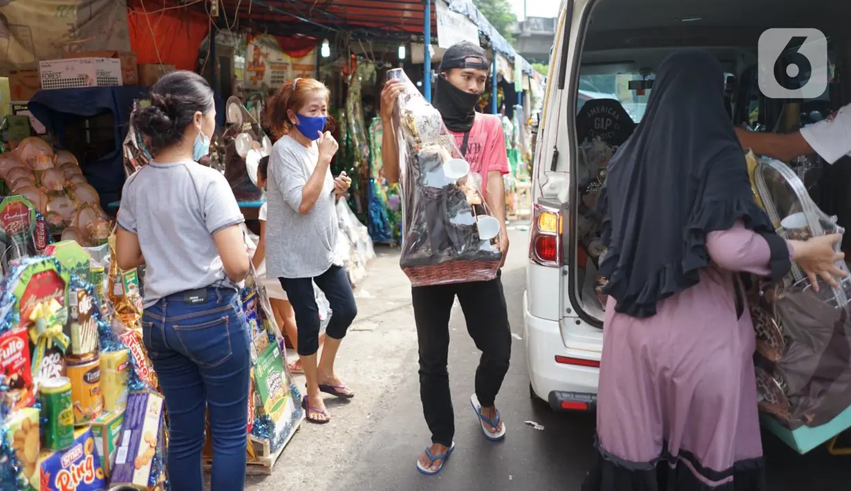 Pedagang melayani pembeli di salah satu pusat penjualan parsel di kawasan Cikini, Jakarta, Rabu (13/5/2020). Selama bulan Ramadan, para pedagang mengaku omzet penjualan parsel turun hingga 90 persen dibandingkan tahun lalu akibat adanya pandemi virus corona COVID-19. (Liputan6.com/Immanuel Antonius)