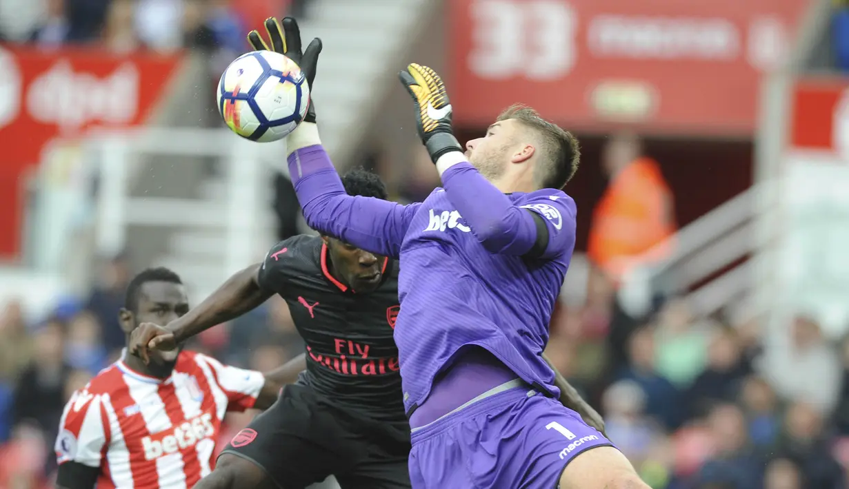 Kiper Stoke City, Jack Butland, berebut bola dengan striker Arsenal, Danny Welbeck, pada laga Premier League di Stadion Bet365, Sabtu (19/8/2017). Stoke City menang 1-0 atas Arsenal. (AP/Rui Vieira)