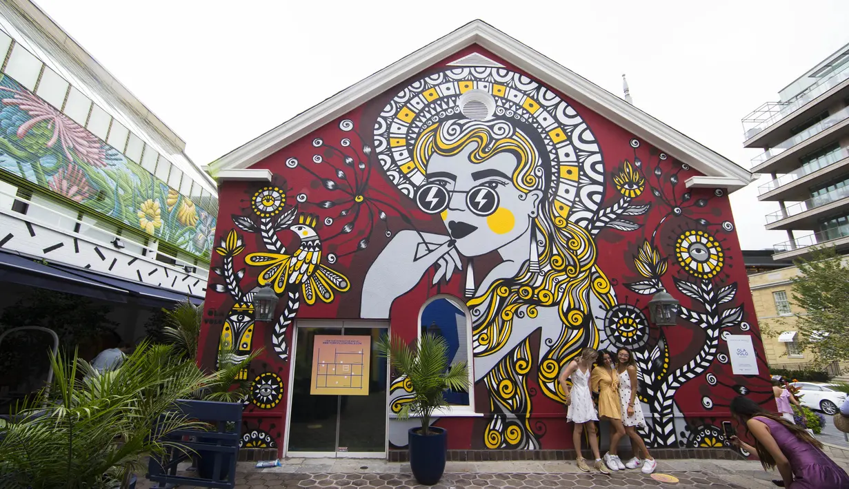 Sejumlah orang berfoto di depan mural dalam acara Yorkville Murals 2020 di Toronto (29/8/2020). Dengan karya mural artistik dan implementasi aktivasi budaya, acara tahunan ini dimulai Jumat (28/8) hingga Minggu (30/8) sebagai perayaan seni publik dan gerakan mural kontemporer. (Xinhua/Zou Zheng)