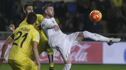 Bek Real Madrid, Sergio Ramos, membuang bola saat menghadapi Villarreal pada laga La Liga Spanyol di Stadion El Madrigal, Spanyol, Minggu (13/12/2015). (AFP/Jose Jordan)