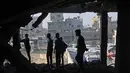 Kementerian Kesehatan Gaza mengatakan ini merupakan pelanggaran terbaru terhadap kesepakatan gencatan senjata rapuh yang berlaku sejak 10 Oktober 2025. Tampak dalam foto, warga Palestina memeriksa puing-puing bangunan yang rusak milik Kementerian Wakaf Agama, yang digunakan sebagai tempat penampungan bagi pengungsi di kawasan Zeitoun, Kota Gaza, pada Kamis 20 November 2025, sehari setelah bangunan tersebut menjadi sasaran serangan militer Israel. (Omar AL-QATTAA/AFP)