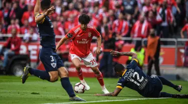 Gelandang Benfica, Joao Felix (tengah) berusaha melewati dua pemain Santa Clara selama pertandingan Liga Portugal di stadion Luz di Porto pada 18 Mei 2019. Pemain 19 tahun ini diboyong Atletico Madrid seharga 126 juta euro atau setara Rp 2 triliun. (AFP Photo/Patricia De Melo Moreira)