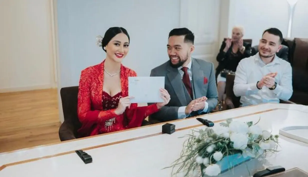 Kebaya brokat warna merah tersebut dipadukan dengan kain batik warna coklat.