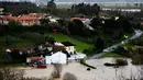 Pemukiman dan jalan utama tertutupi oleh luapan banjir yang terjadi di Coimbra, Portugal (14/2/2016). Badai besar yang melanda seluruh negara bagian Portugal menyebabkan gelombang tinggi dan banjir. (AFP Photo /Francisco Leong)