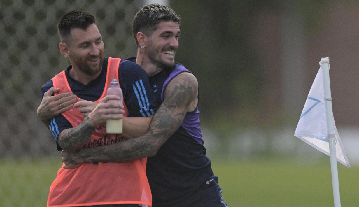 Pemain Timnas Argentina, Lionel Messi (kiri) dan Rodrigo De Paul, bersenda gurau dalam sesi latihan yang berlangsung di Ezeiza, Buenos Aires, Rabu (11/10/2023) WIB. Kedua pemain tersebut tak sungkan menunjukkan keakraban sejak bermain bareng di Timnas Argentina pada tahun 2018. (AFP/Juan Mabromata)