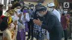 Gubernur DKI Jakarta, Anies Baswedan menyapa seorang anak umat Hindu saat menghadiri Upacara Tawur Agung Kesanga di Pura Aditya Jaya, Pulo Gadung, Rabu (2/3/2022). Upacara Tawur Agung Kesanga merupakan perayaan jelang Hari Suci Nyepi yang jatuh pada Kamis (3/3). (Liputan6.com/Herman Zakharia)