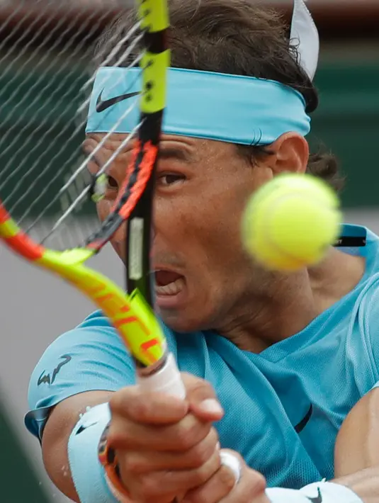 Petenis Spanyol, Rafael Nadal mengembalikan bola ke arah Dominic Thien dari Austria pada partai final Prancis Terbuka di Stadion Roland Garros, Minggu (10/6). Nadal menyelesaikan pertandingan dalam waktu dua jam 42 menit. (AP/Alessandra Tarantino)